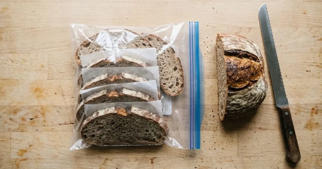 Tranches de pain rangées dans un sac de congélation à côté de la miche et d'un couteau