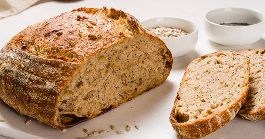 Pain au levain complet tranché avec des bols de graines