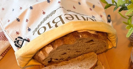 Pain au levain tranché dans un sac à pain MieBio, café et confiture
